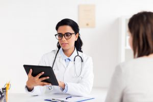 doctor with tablet pc and woman at hospital
